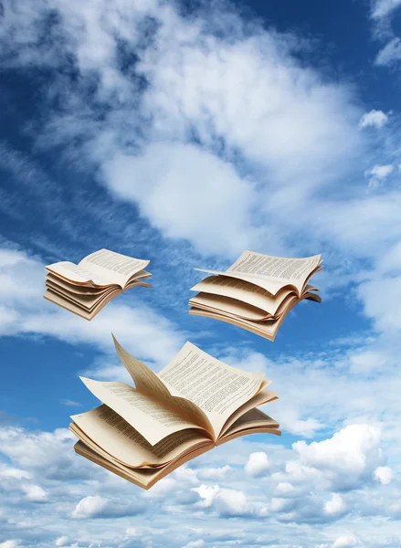 Drei aufgeschlagene Bücher fliegen auf blauem Himmel — Stockfoto