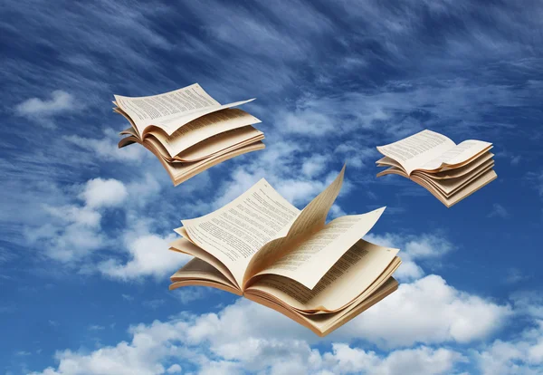 Três livros abertos voando no céu azul — Fotografia de Stock