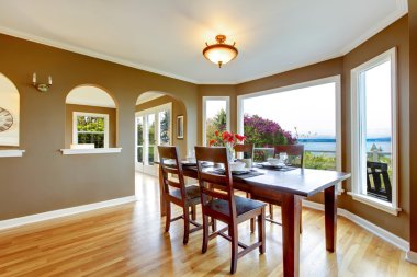 Dining room with brown walls and wood table. clipart