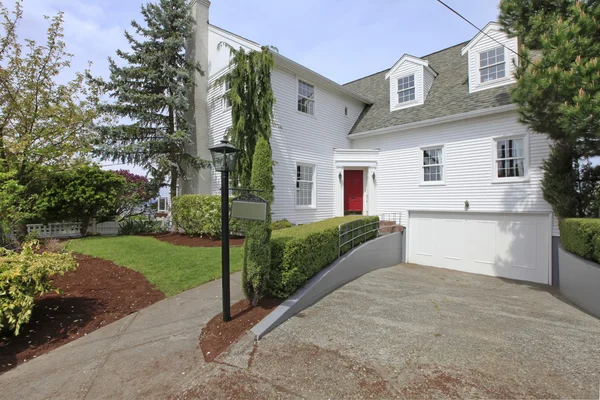 Huis koloniaal wit met rode deur exterieur voorzijde. — Stockfoto