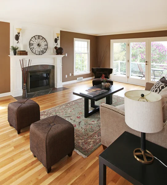Braunes Wohnzimmer mit weißem Kamin und Luxusmöbeln. — Stockfoto