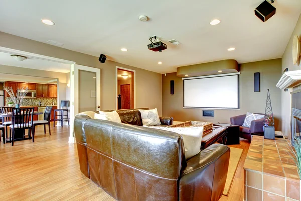 Stort vardagsrum med bruna väggar och skinnsoffa. — Stockfoto