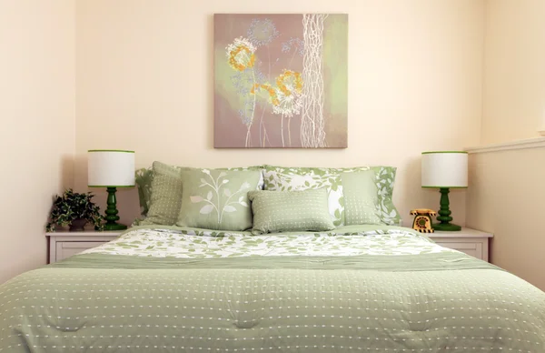 Cama simple verde con dos lámparas y arte . — Foto de Stock