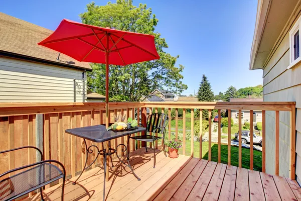 Deck with red umbrella with warm wood. — Stock Photo, Image