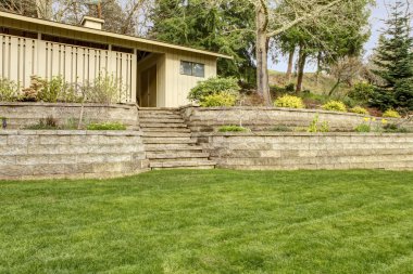 Retaining brick with steps wall with garage building. clipart