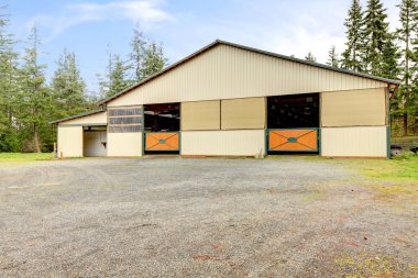 Horse arena exterior building with two lareg gates. clipart