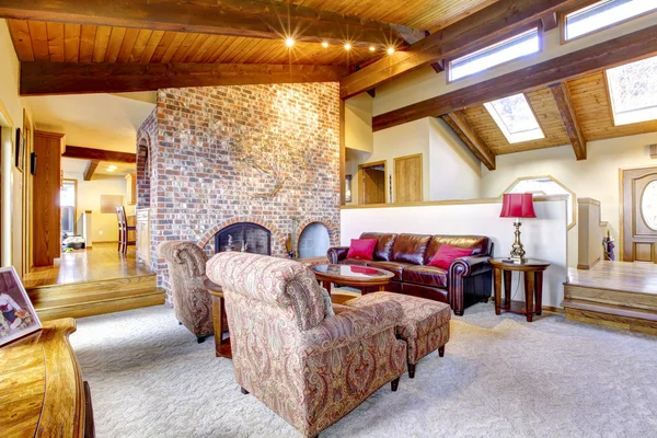 Sala de estar con techo de madera con chimenea de ladrillo . — Foto de Stock