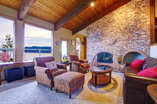 Belle salle de séjour rustique avec cheminée et plafond en bois . — Photo