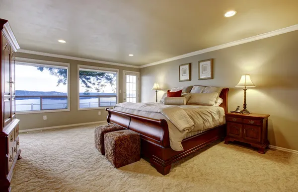 Großes Schlafzimmer mit Holzbett und Blick auf das Wasser. — Stockfoto