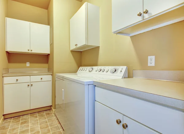 Çamaşır odası dolapları beyaz ve sarı duvarlar. — Stok fotoğraf