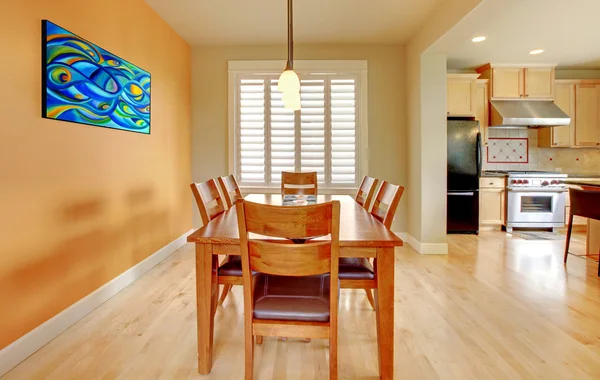 Sala de jantar laranja com piso em madeira e cozinha . — Fotografia de Stock