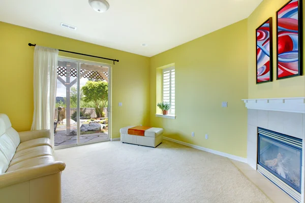 Gele woonkamer met open haard en kunst. — Stockfoto