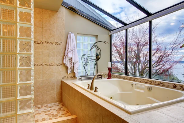 Grote bad met venster muur met zicht op water. — Stockfoto