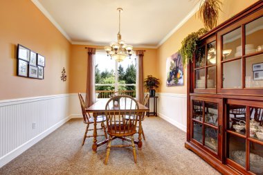 Peach dining room with beige carpet with white border. clipart