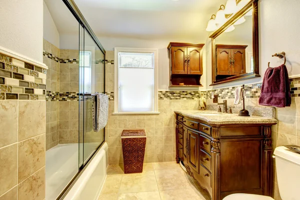 Fint badrum med natursten plattor och trä skåp. — Stockfoto