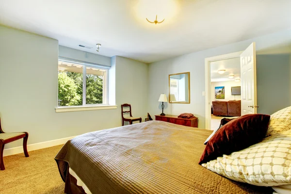 Gäst sovrum med blå väggar och brun säng. — Stockfoto