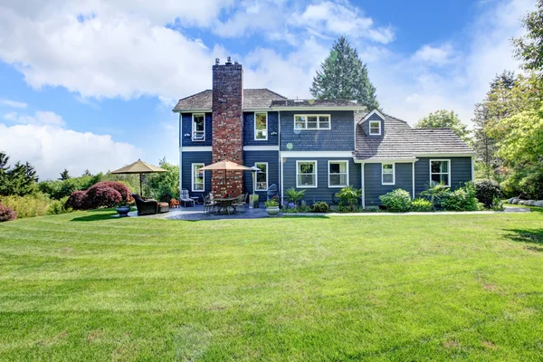 Grande maison bleue avec herbe et cheminée . — Photo