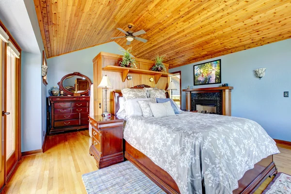 Blauwe slaapkamer met houten plafond en open haard interieur. — Stockfoto