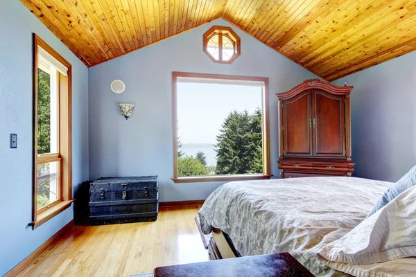 Modrá ložnice s dřevěným stropem a postel interiér. — Stock fotografie