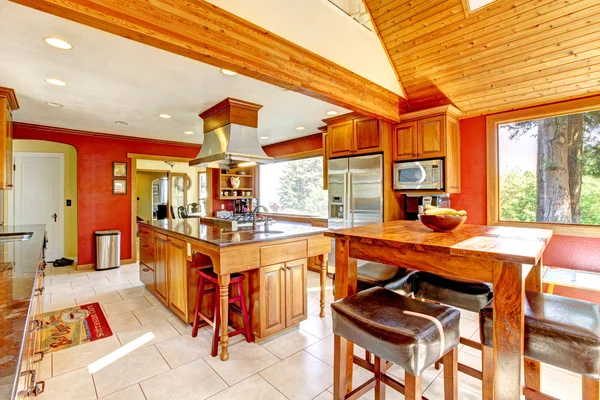 Große Küche mit roten Wänden und holzgewölbter Decke. — Stockfoto