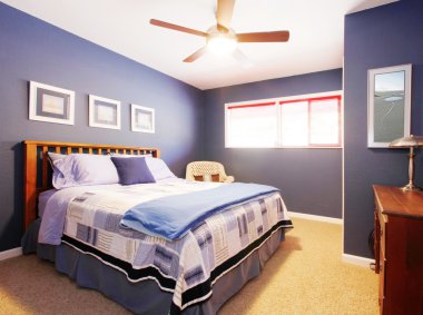 Blue bedroom interioe with navy bedding. clipart