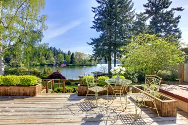 Large deck with chairs and water lake view.. clipart