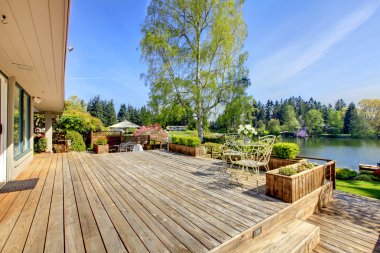 Large wood deck with lake and spring landscape. clipart