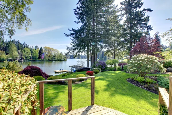 Vista al lago patio trasero con cubierta y paisaje de primavera . — Foto de Stock