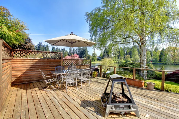 Große Terrasse mit Möbeln und Sonnenschirm mit Seeblick. — Stockfoto