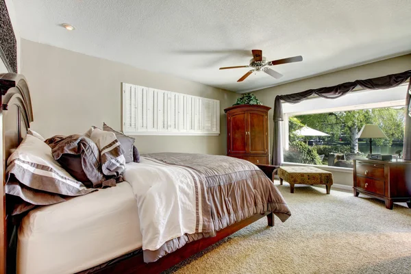 Элегантная большая спальня с окном и коричневой мебелью . — стоковое фото