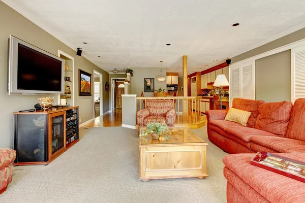 Интерьер гостиной с красным диваном, телевизором и бежевыми цветами . — стоковое фото