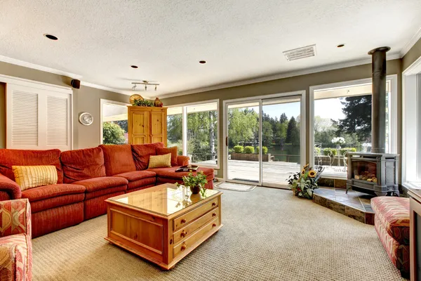 Интерьер гостиной с красным диваном и плитой . — стоковое фото