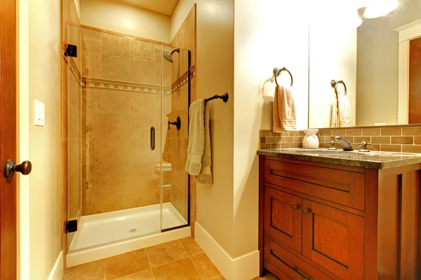 Banheiro com armário de madeira e chuveiro de azulejo . — Fotografia de Stock