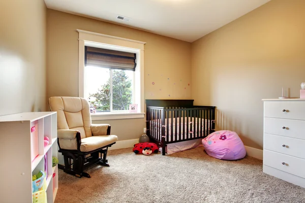 Salle de soins pour bébé fille avec lit en bois brun . — Photo