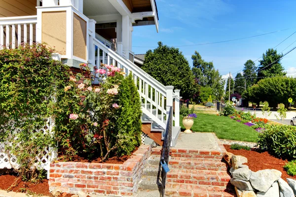 Hauseingangstreppe aus Ziegeln und Rosen mit Blick auf die Straße. — Stockfoto