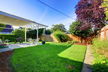 Backyard with fence and house covered deck. clipart