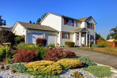 White two story AMerican housee front exterior with large garage. clipart