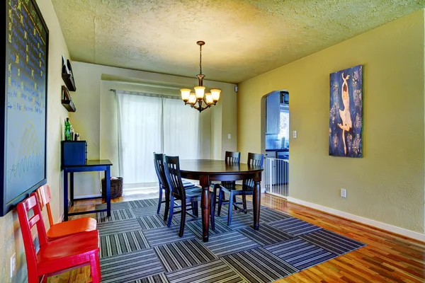 Esszimmer mit grünen Wänden, schwarzem Tisch und grauem Teppich. — Stockfoto