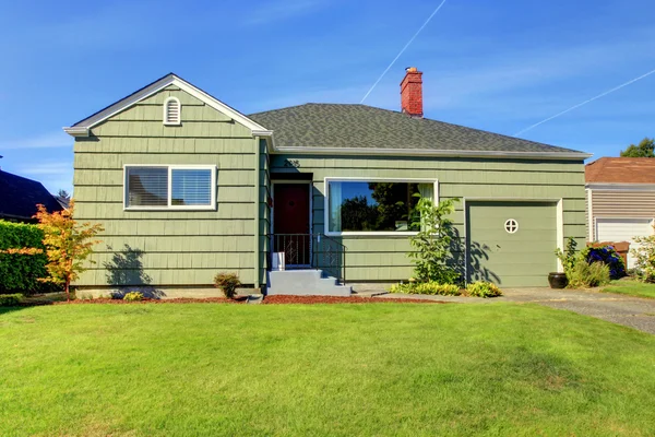 Verde piccola casa verde con porta del garage . — Foto Stock