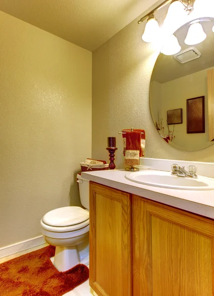Banheiro com paredes verdes e armário de pia de madeira . — Fotografia de Stock