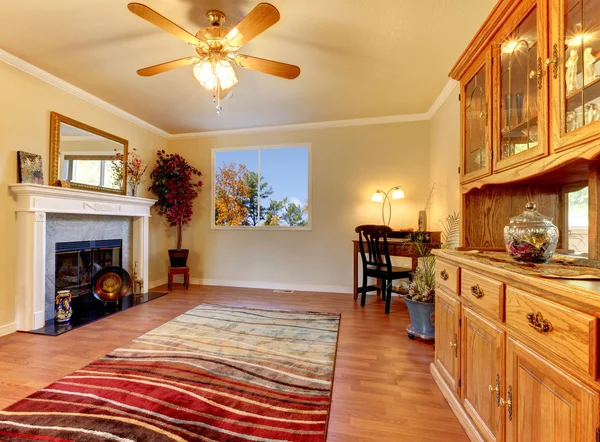 Salon avec cheminée et murs beiges avec armoire hutch . — Photo