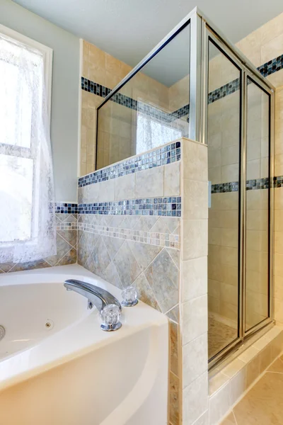 Dusch med beige och blått kakel och vit tub. — Stockfoto