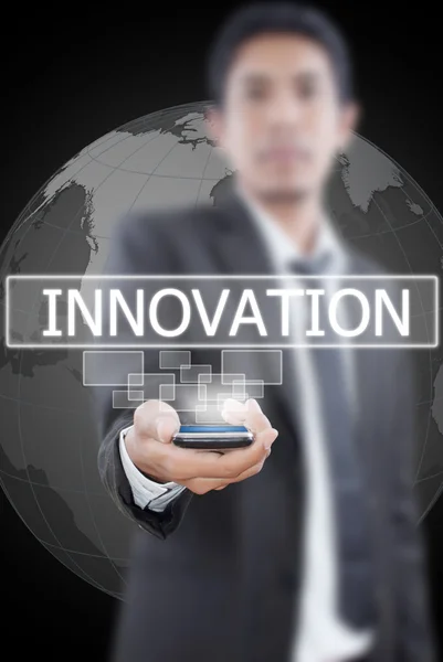 Podnikatel drží slovo inovace z mobilního telefonu. — Stock fotografie