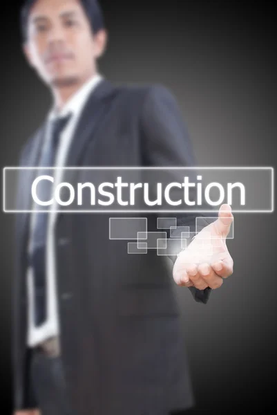 Podnikatel drží stavební slovo na tabuli. — Stock fotografie