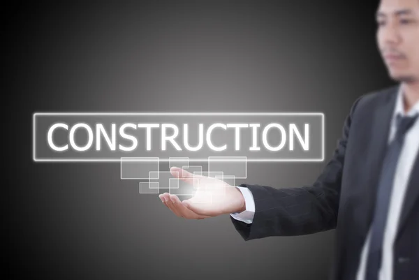 Бизнесмен, держащий слово "Строительство" на доске . — стоковое фото
