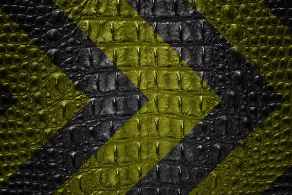 Жовтий і чорний знак попередження на шкірі крокодила . — стокове фото