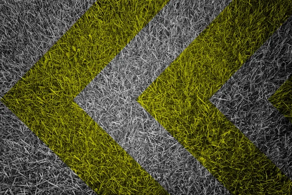 Sinal de aviso amarelo e preto na textura da grama — Fotografia de Stock