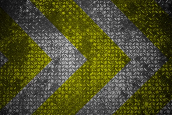 Yellow and black warning sign on steel texture.