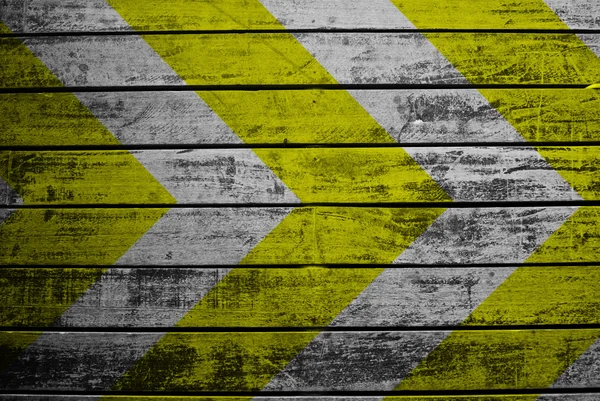Sinal de aviso amarelo e preto na textura de madeira — Fotografia de Stock