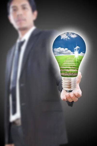 Asian businessman giving bulb for nature — Stock Photo, Image